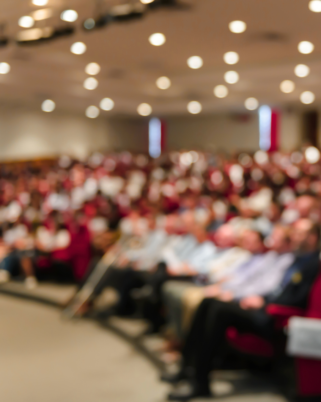 Une salle de conférence remplie de personnes assises, probablement lors d'une réunion ou d'une conférence.