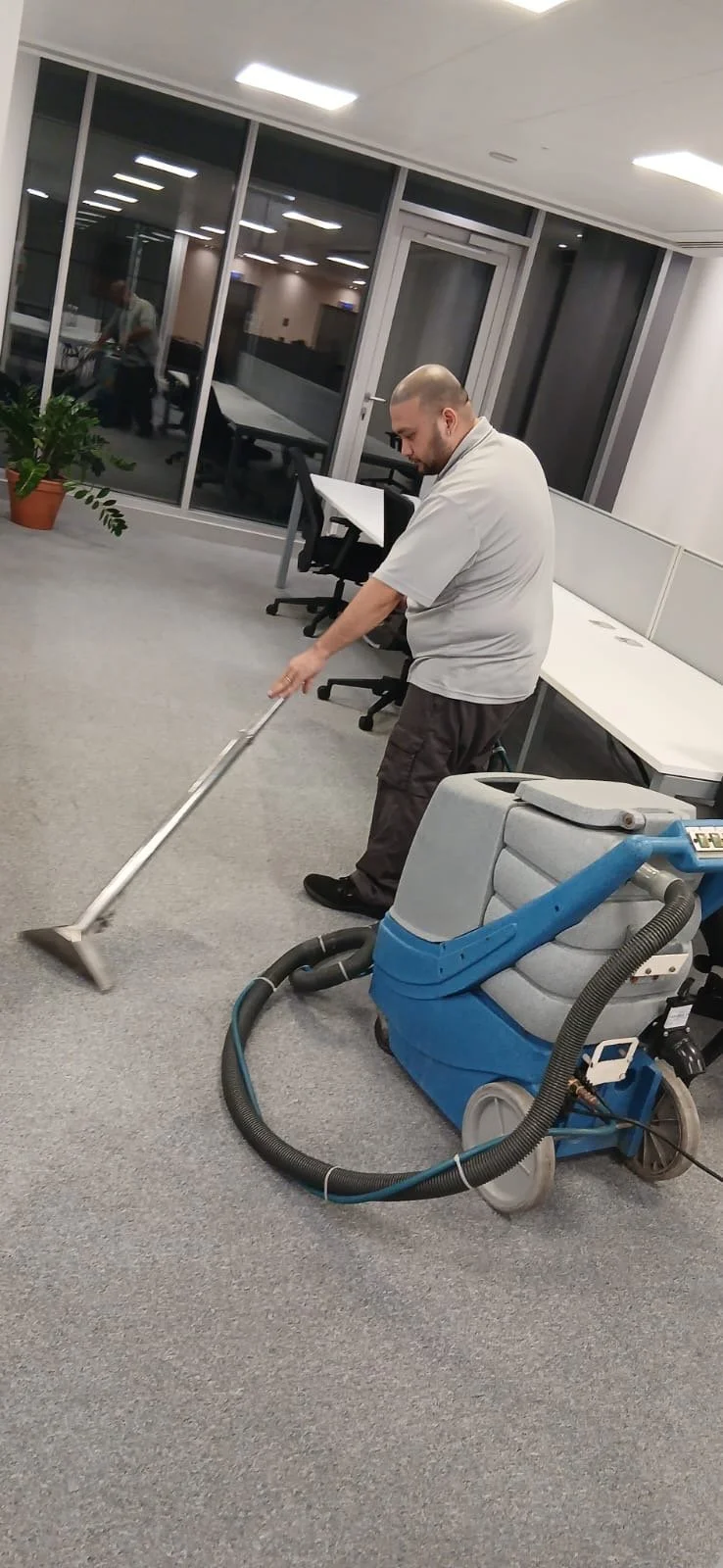 Technician deep cleaning office carpet with professional equipment