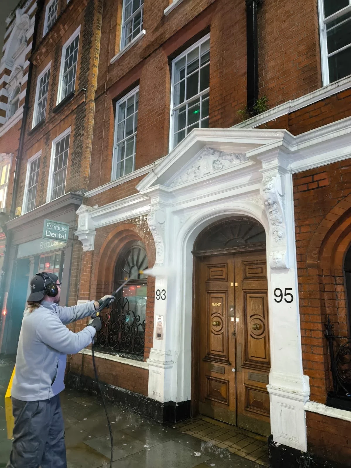 Professional jet washing service cleaning exterior surfaces around commercial buildings