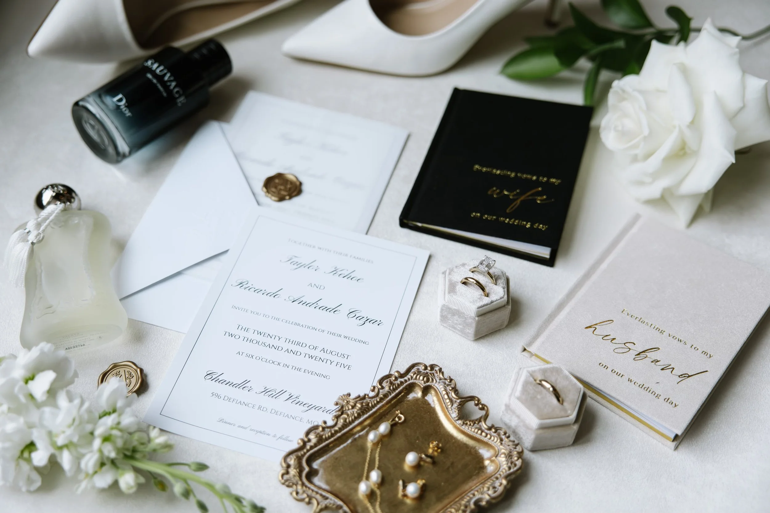 A bride and groom walking arm-in-arm through a confetti shower at an outdoor wedding ceremony, with an A-frame floral arch behind them and friends throwing confetti from either side.