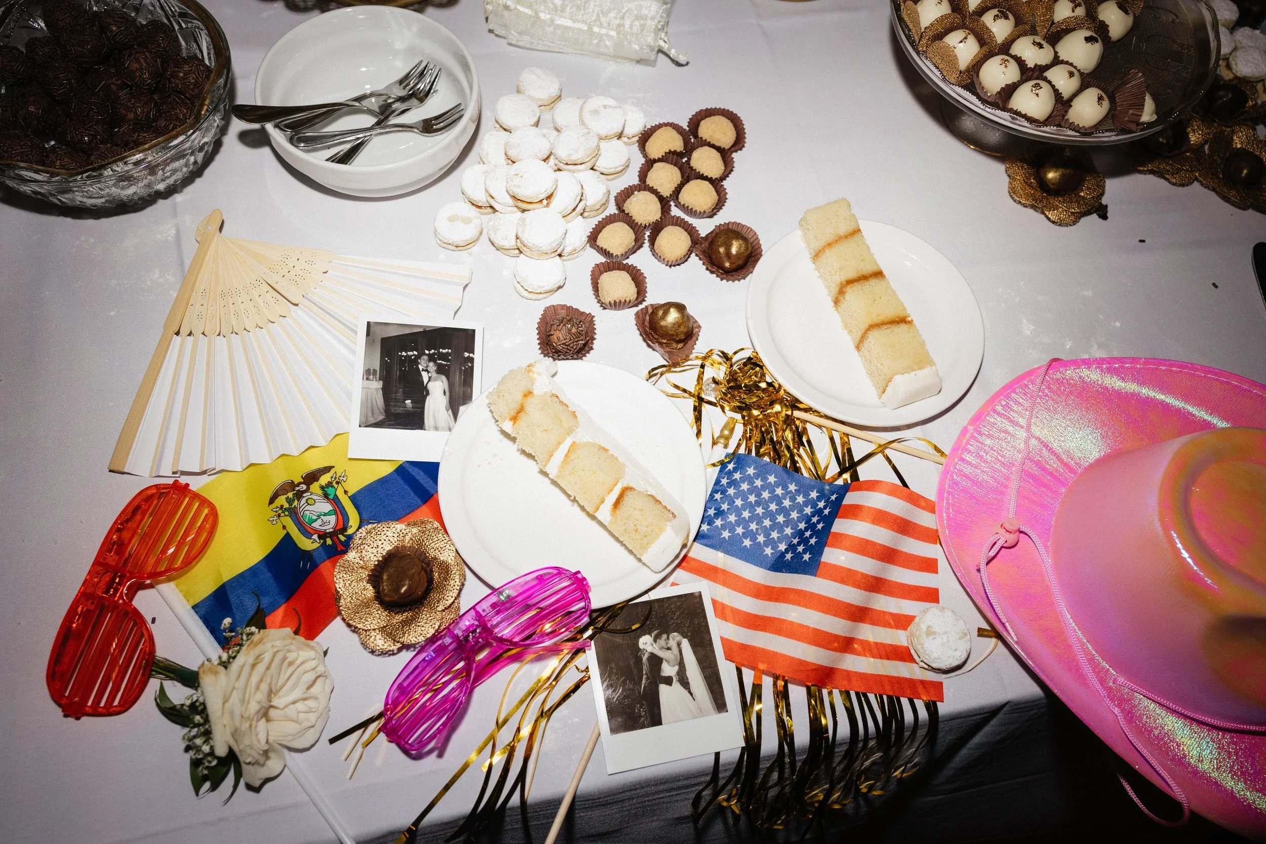 A bride and groom embrace during outdoor wedding ceremony on a sunny day, with guests in the background.