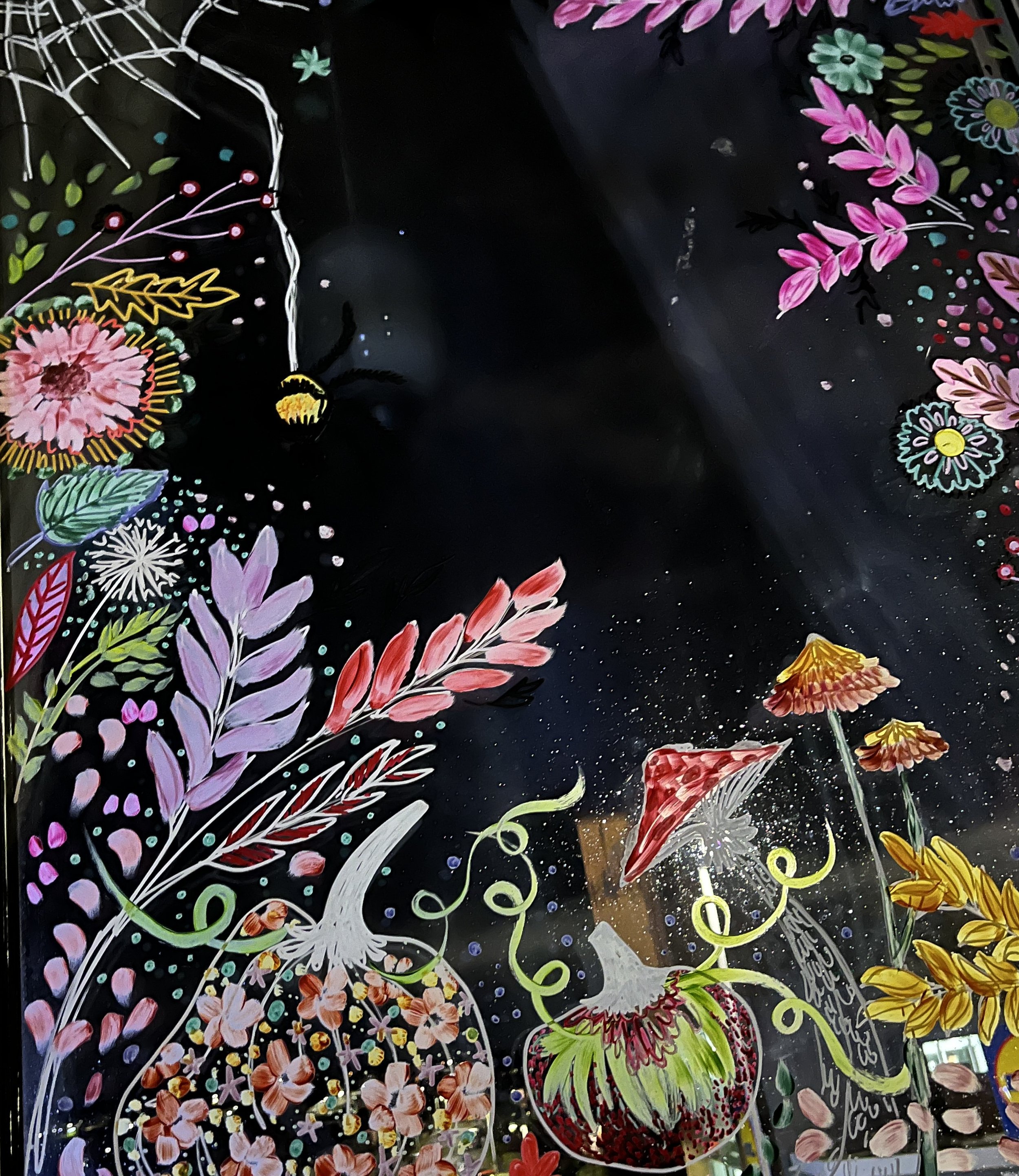 Colorful, whimsical floral illustration with various flowers, plants, and potted plants, set against a black background.