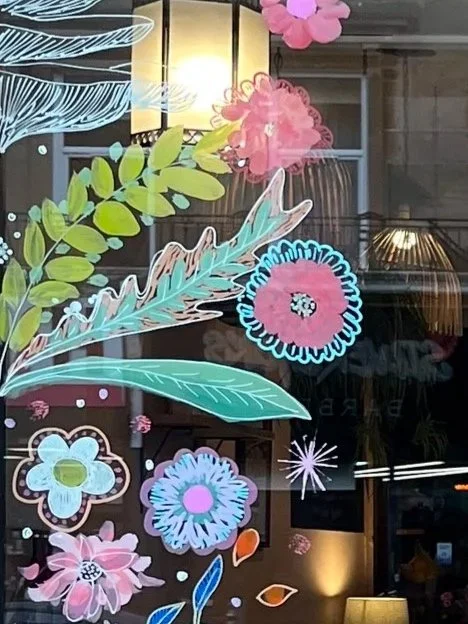 Decorative floral and leaf designs on a glass window.