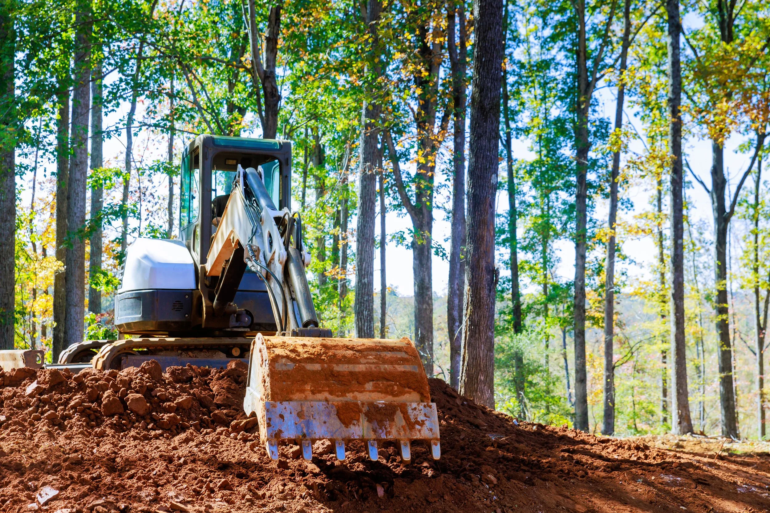 excavator clearing soil from a residential yard