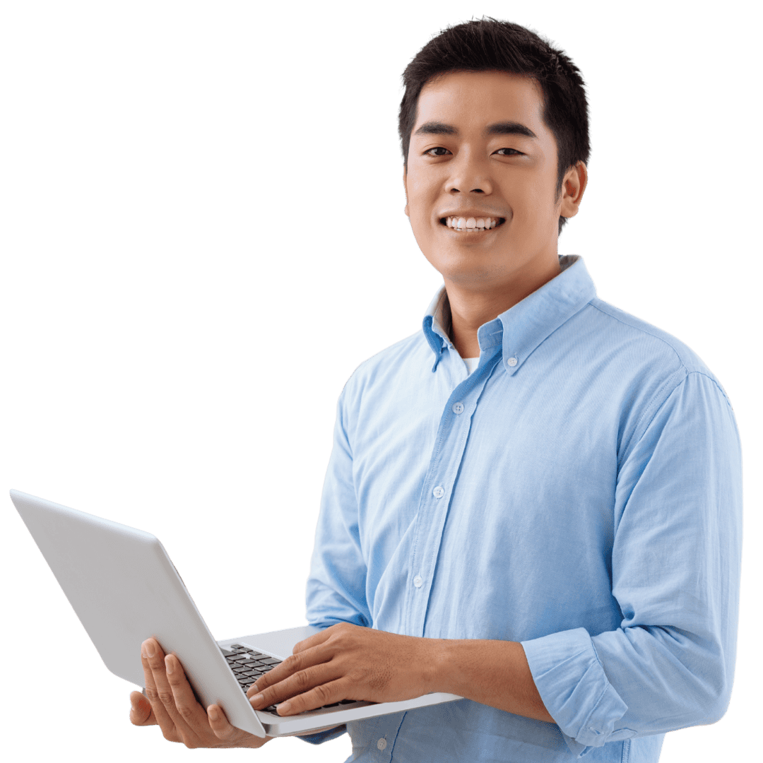 Smiling young man in a light blue shirt holding a laptop, standing against a black background.
