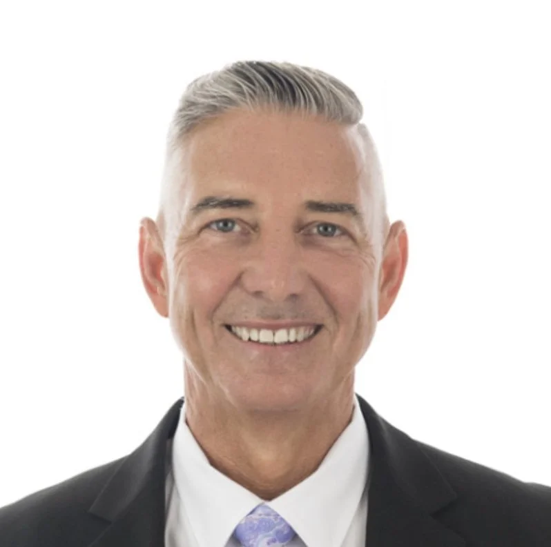 Smiling man who used facebook ads for real estate agents in suit and tie