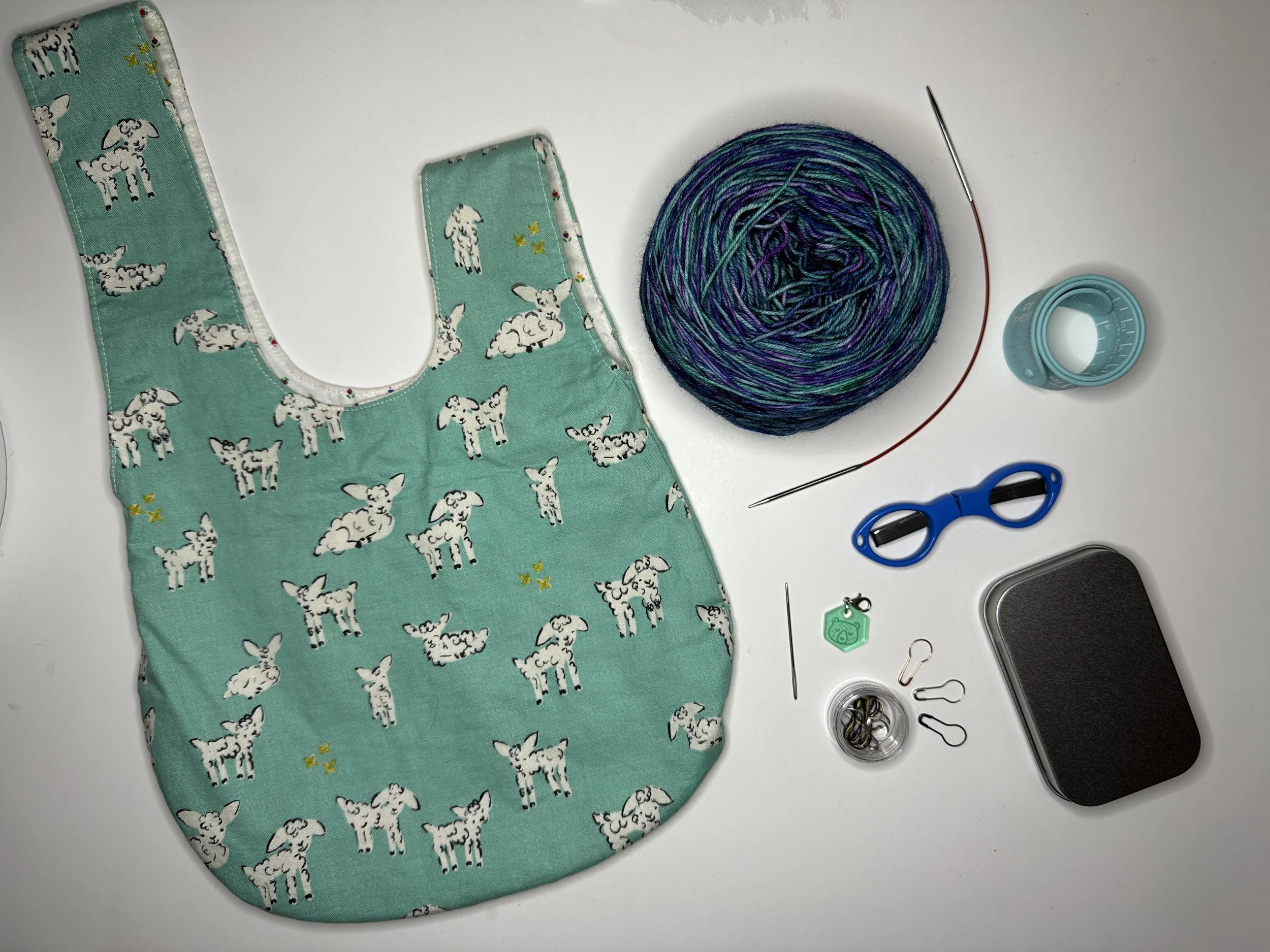 Hand holding a circular needle with rows of ribbed knitting on the needles