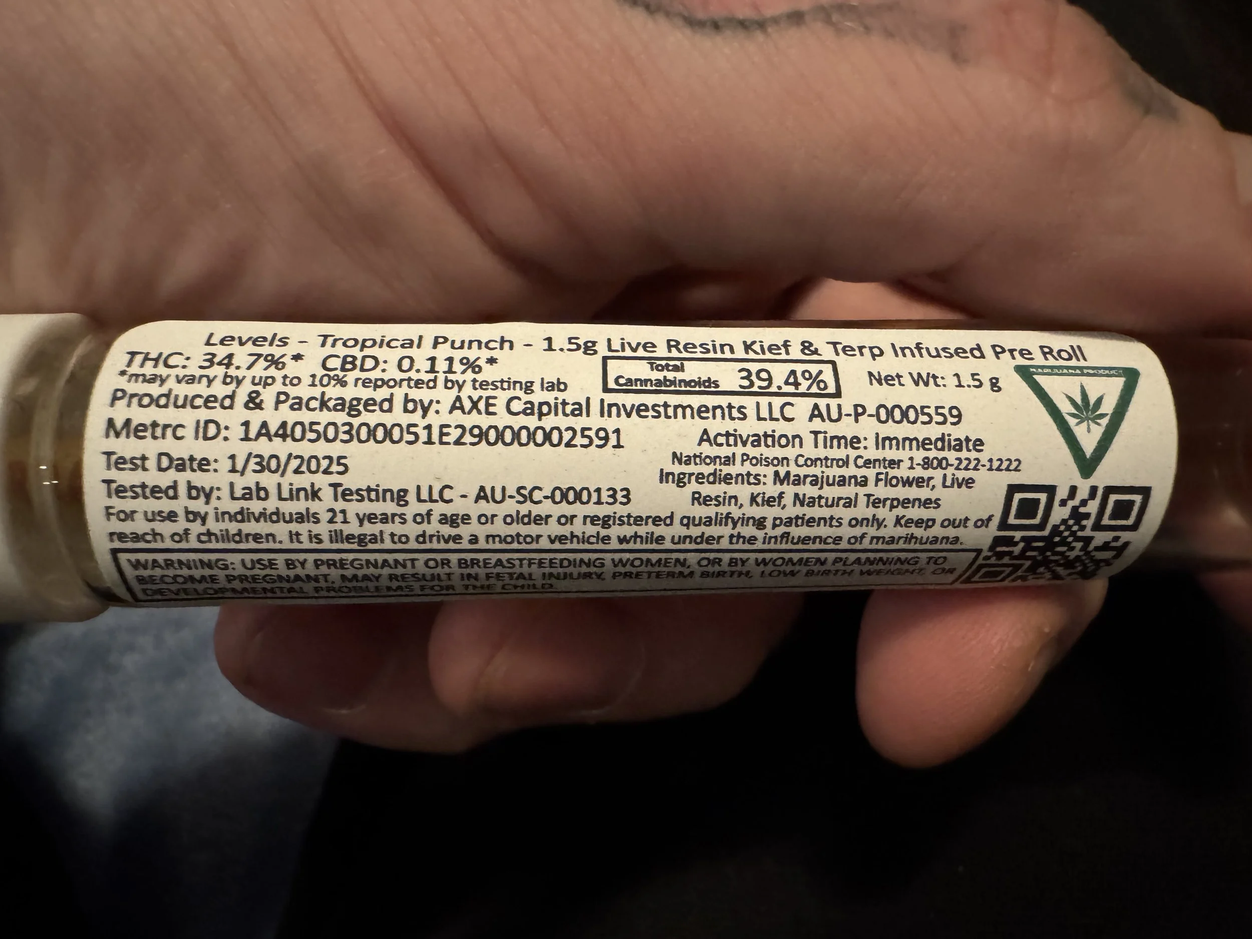 Close-up of a Michigan cannabis pre-roll label showing THC percentage, METRC tracking number, testing lab information, ingredients, and activation time.