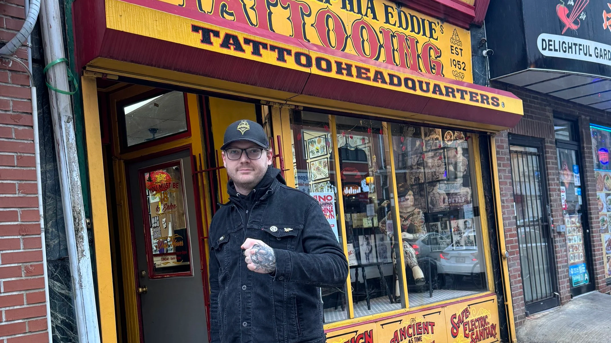 Michael Hadley standing outside Philadelphia Eddie’s Tattoo Headquarters during a visit to the historic tattoo shop.