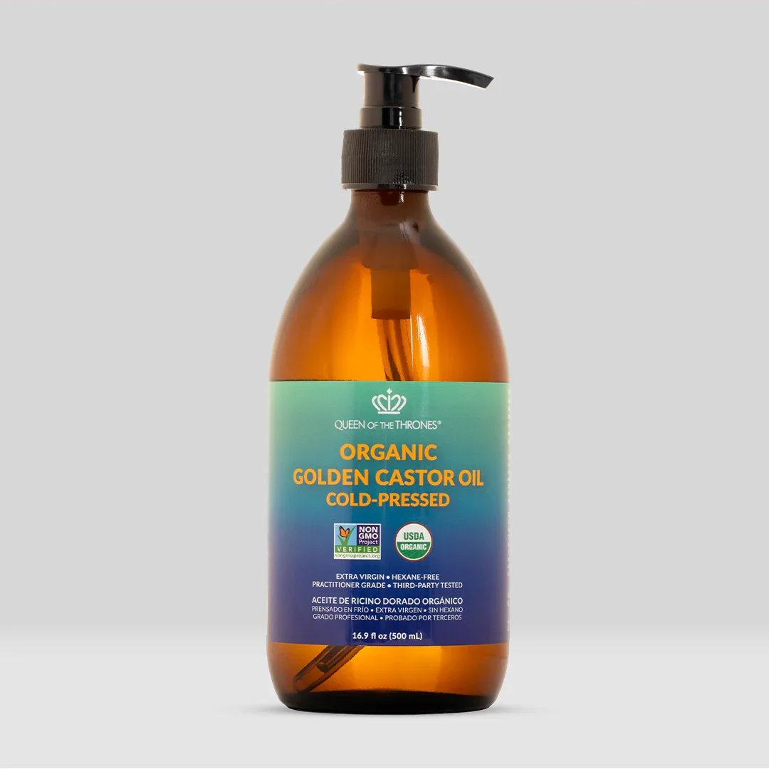 Amber glass bottle with a black pump dispenser labeled 'Organic Golden Castor Oil Cold-Pressed' from Queen of the Thrones. The label features certification logos including USDA Organic and Non-GMO Project Verified.