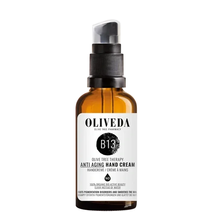 Amber glass bottle of Oliveda B13 anti-aging hand cream with black pump dispenser and white label with black text.