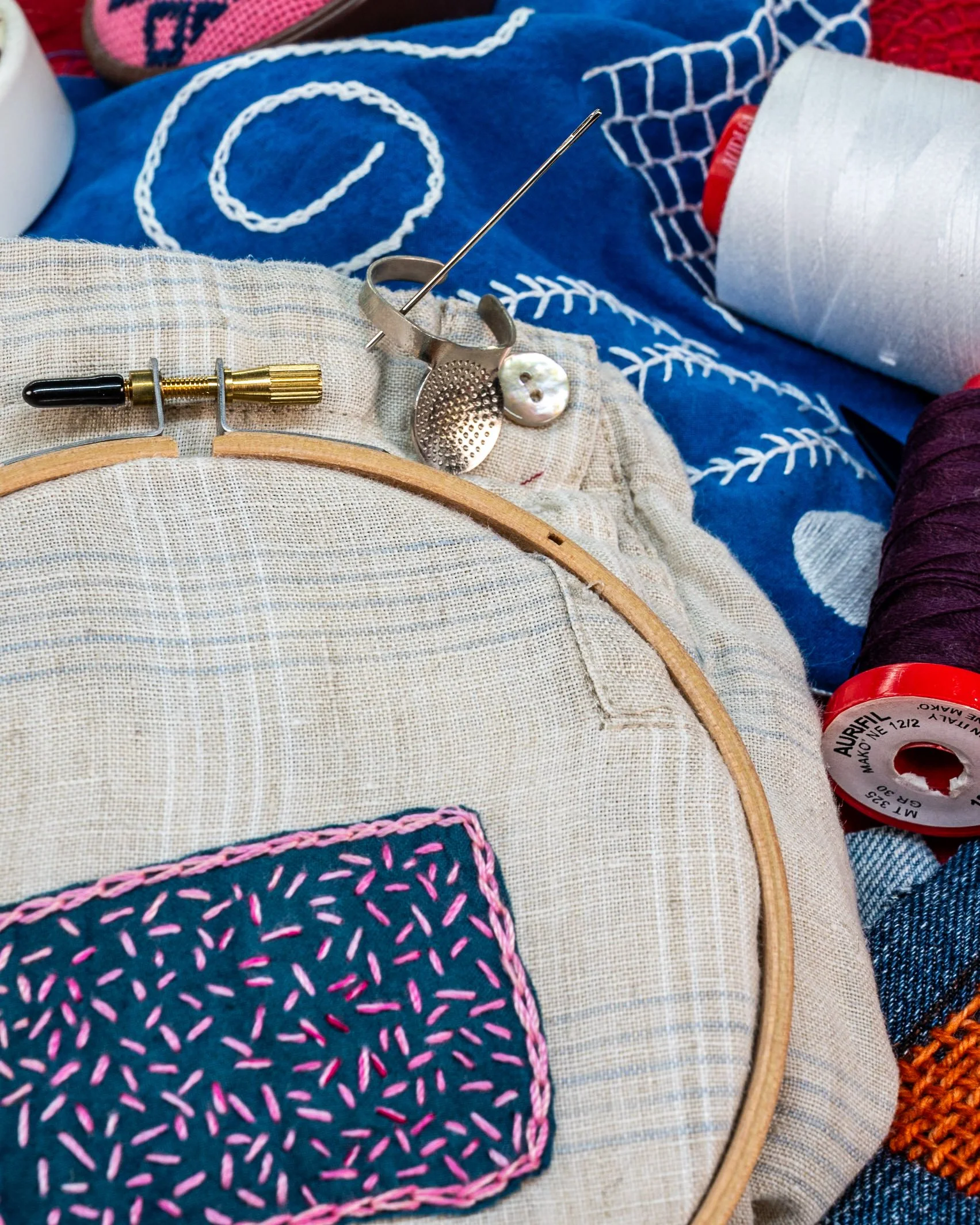photo showing mending patch in a wood hoop with seed stitch and chain stitch anchoring it