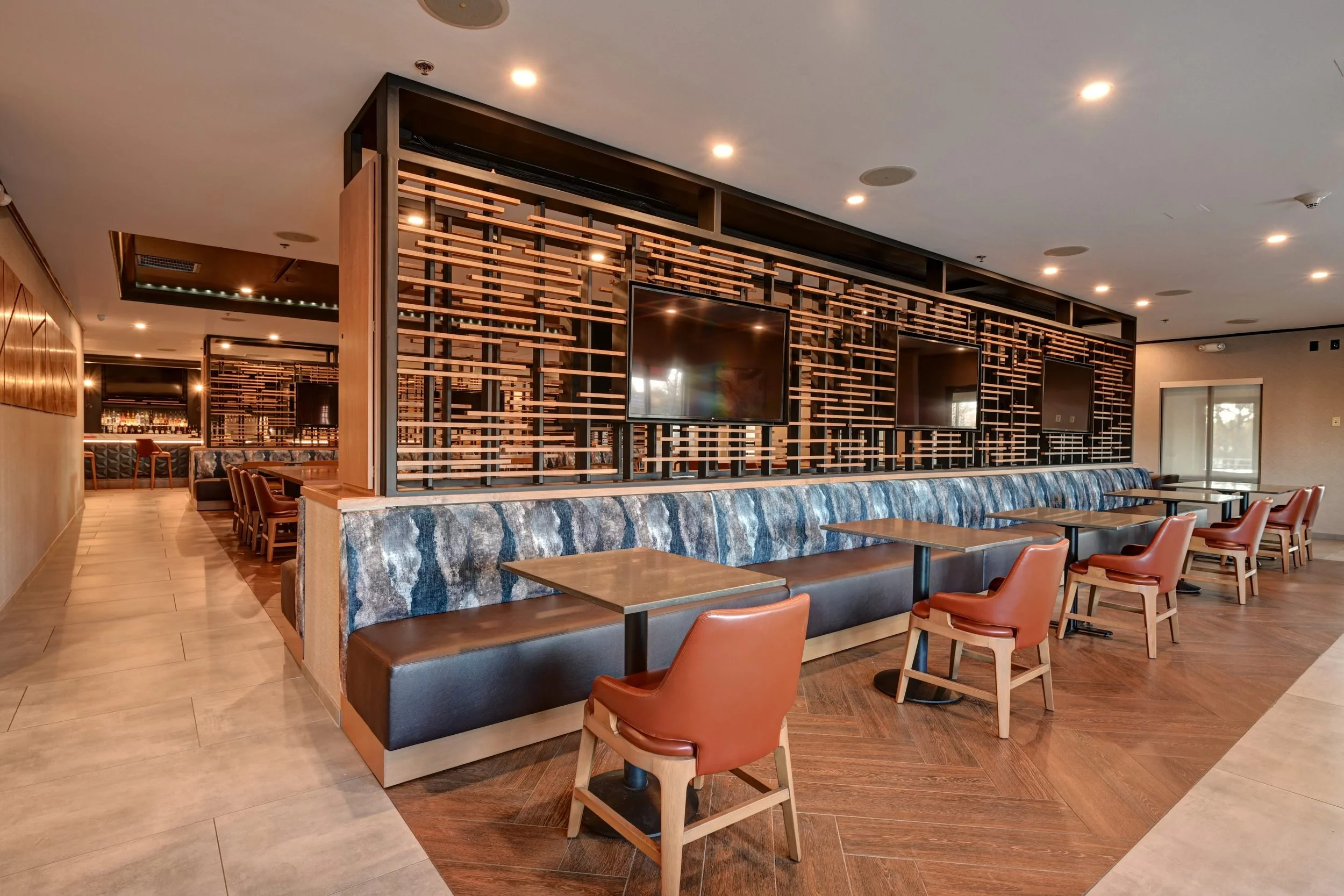 Interior view of The Tower Tap & Grill showing the main dining area with tables, bar seating, and multiple TVs for sports.