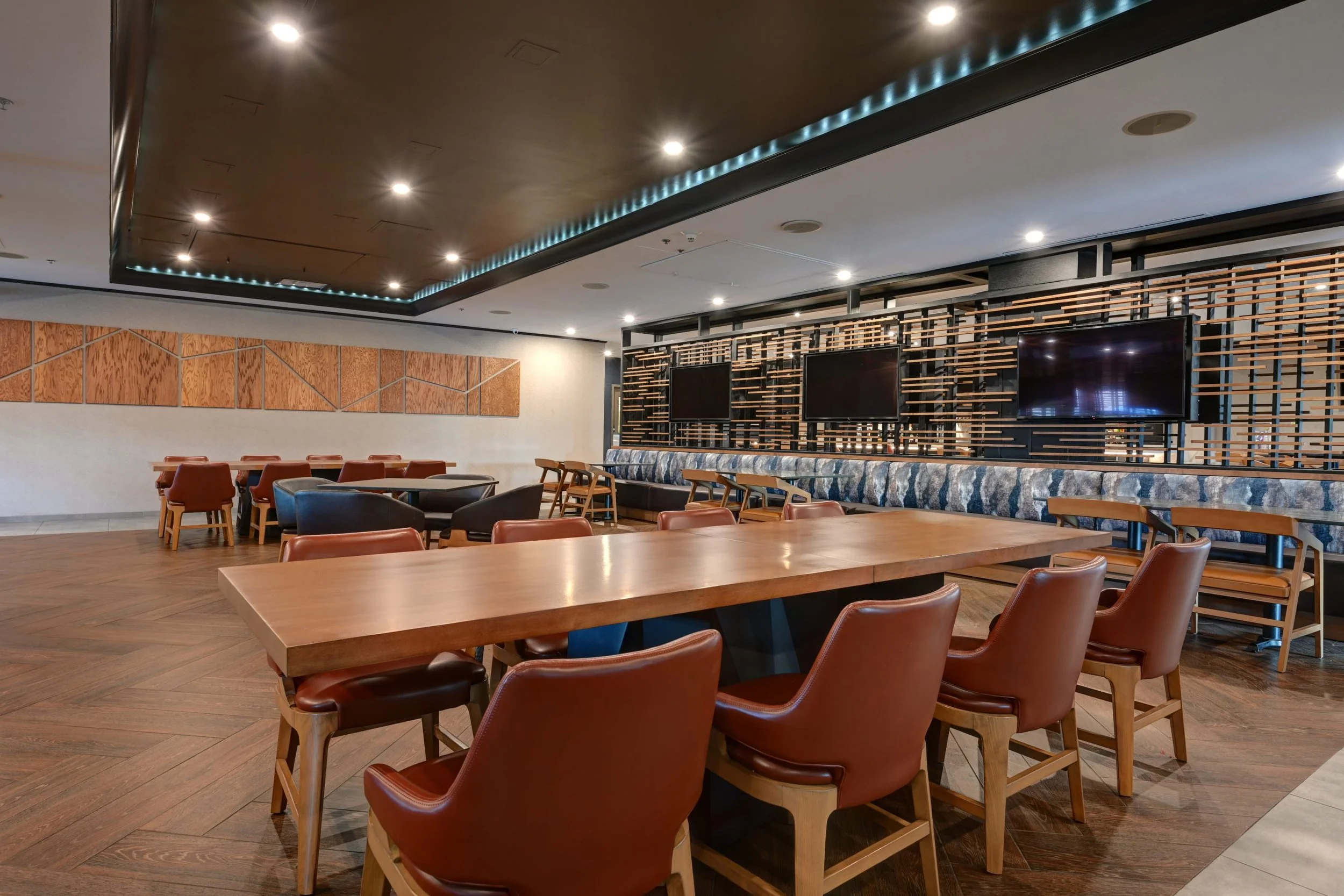 View of The Tower Tap & Grill interior with bar seating, local taps, and big-screen TVs showing live games.