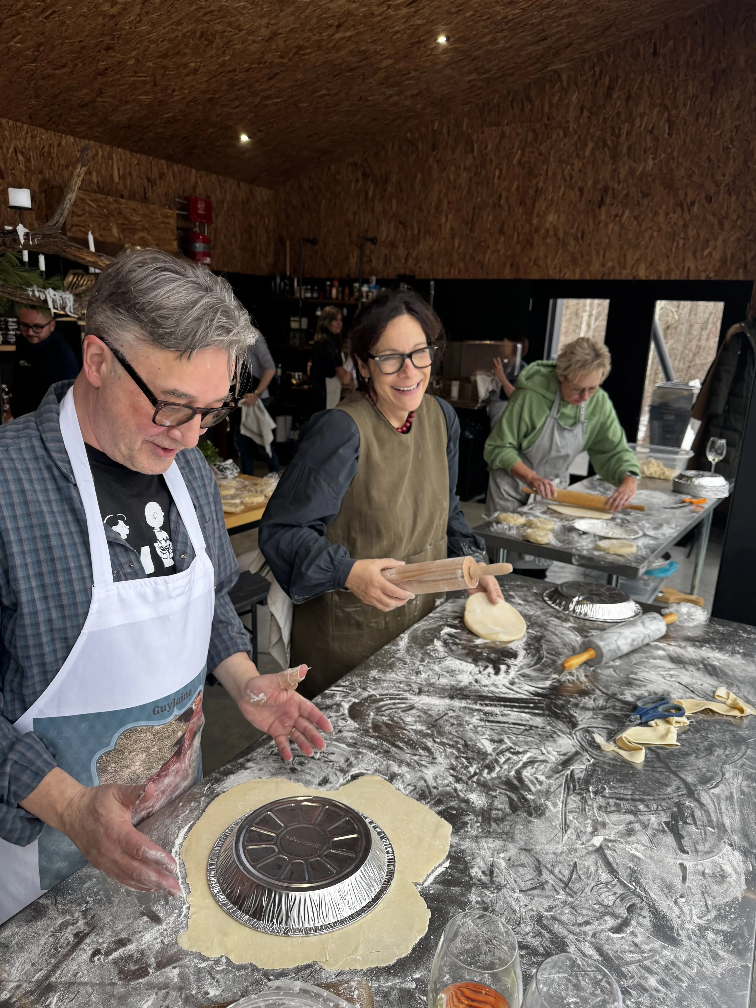 Groupe de personnes ponct, chef cuisinier, en train de faire de la pâte à pizza dans une cuisine moderne.