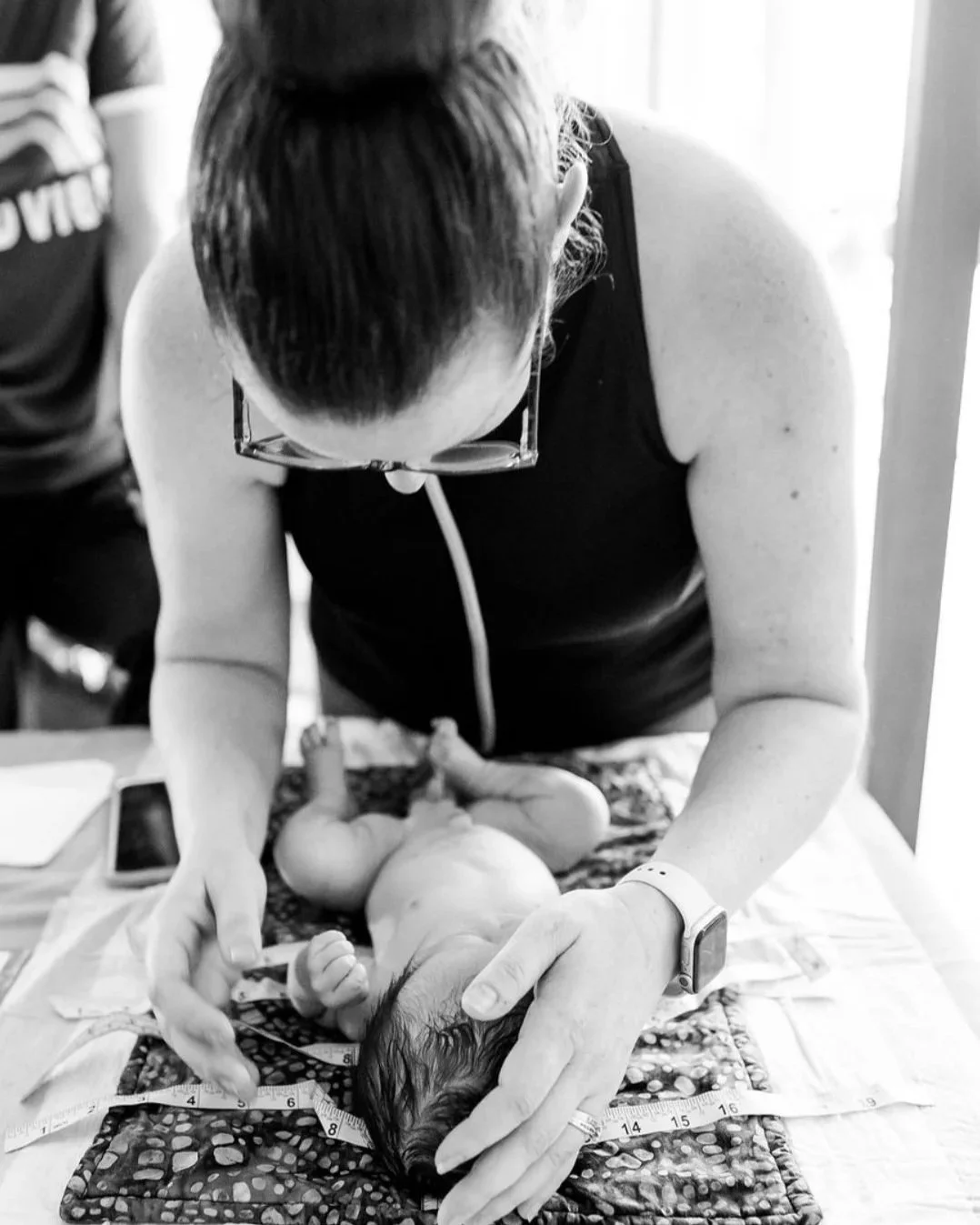 A Licensed midwife performs a newborn exam a newborn baby at a home birth in Los Angeles. 
