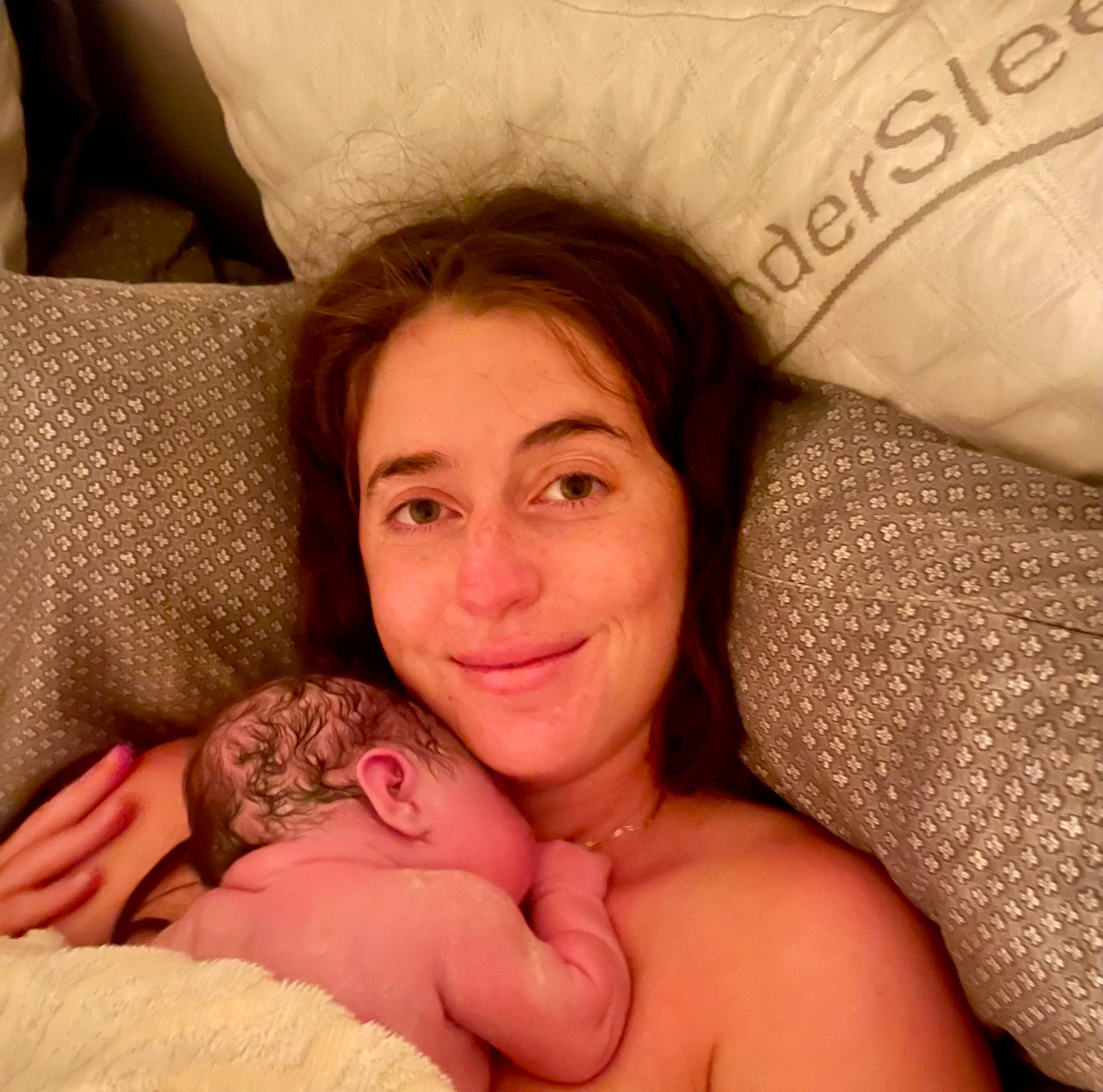 A happy woman holding her newborn baby after a beautful water birth in Los Angeles. 