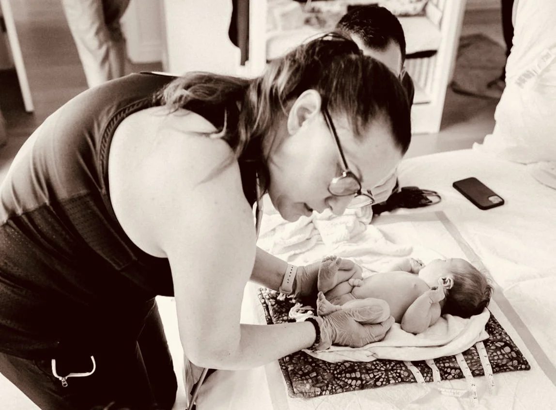 A licensed midwife performing a newborn exam at a home birth in Los Angeles. 