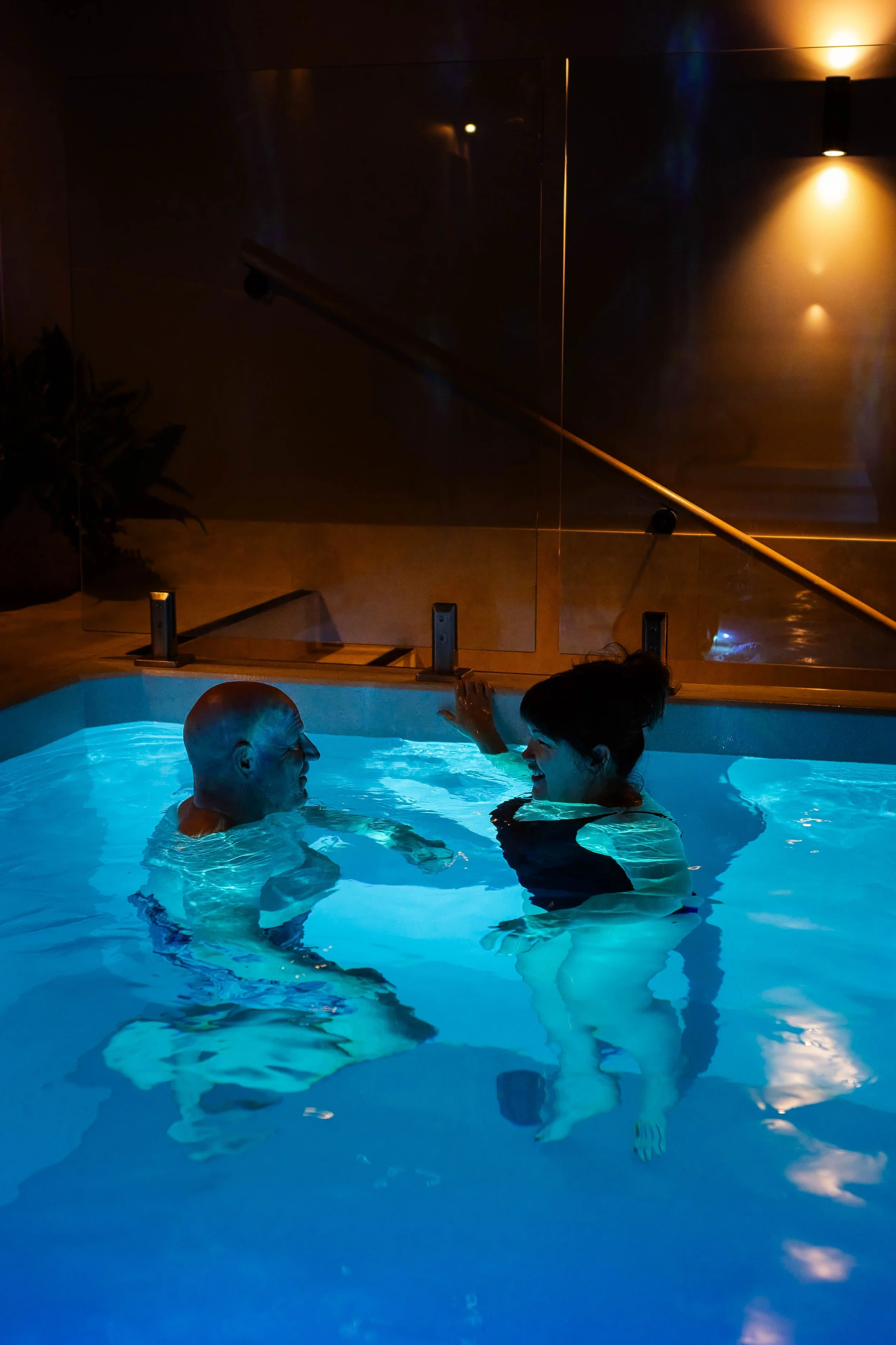A man and a woman enjoying the swim in the hot pool.