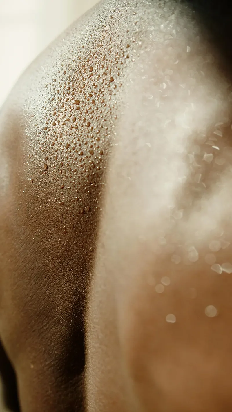Close-up of a person's shoulder with wet skin. 