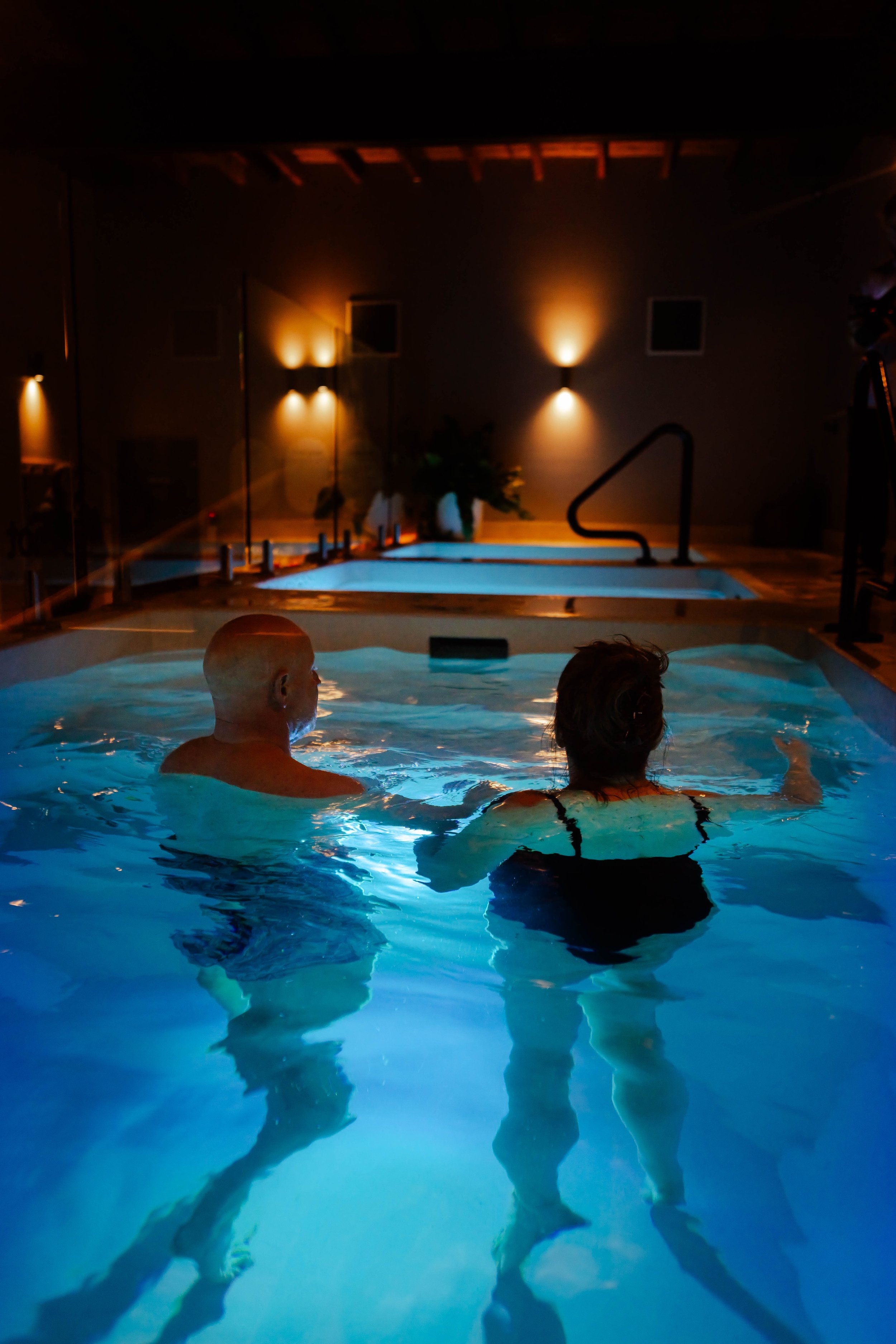 A man and a woman in a cold plunge pool, exploring their flow through meditation.