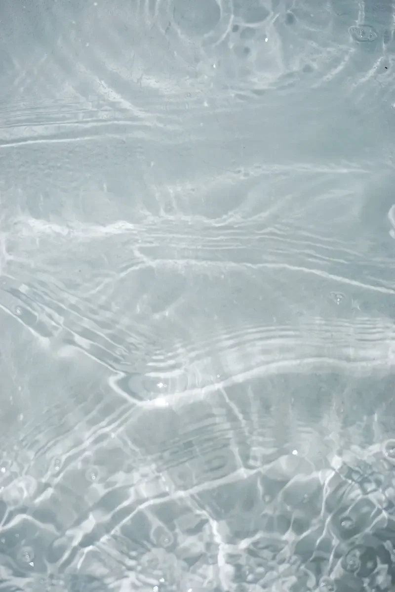 Close-up of clear water with gentle ripples and light reflections.