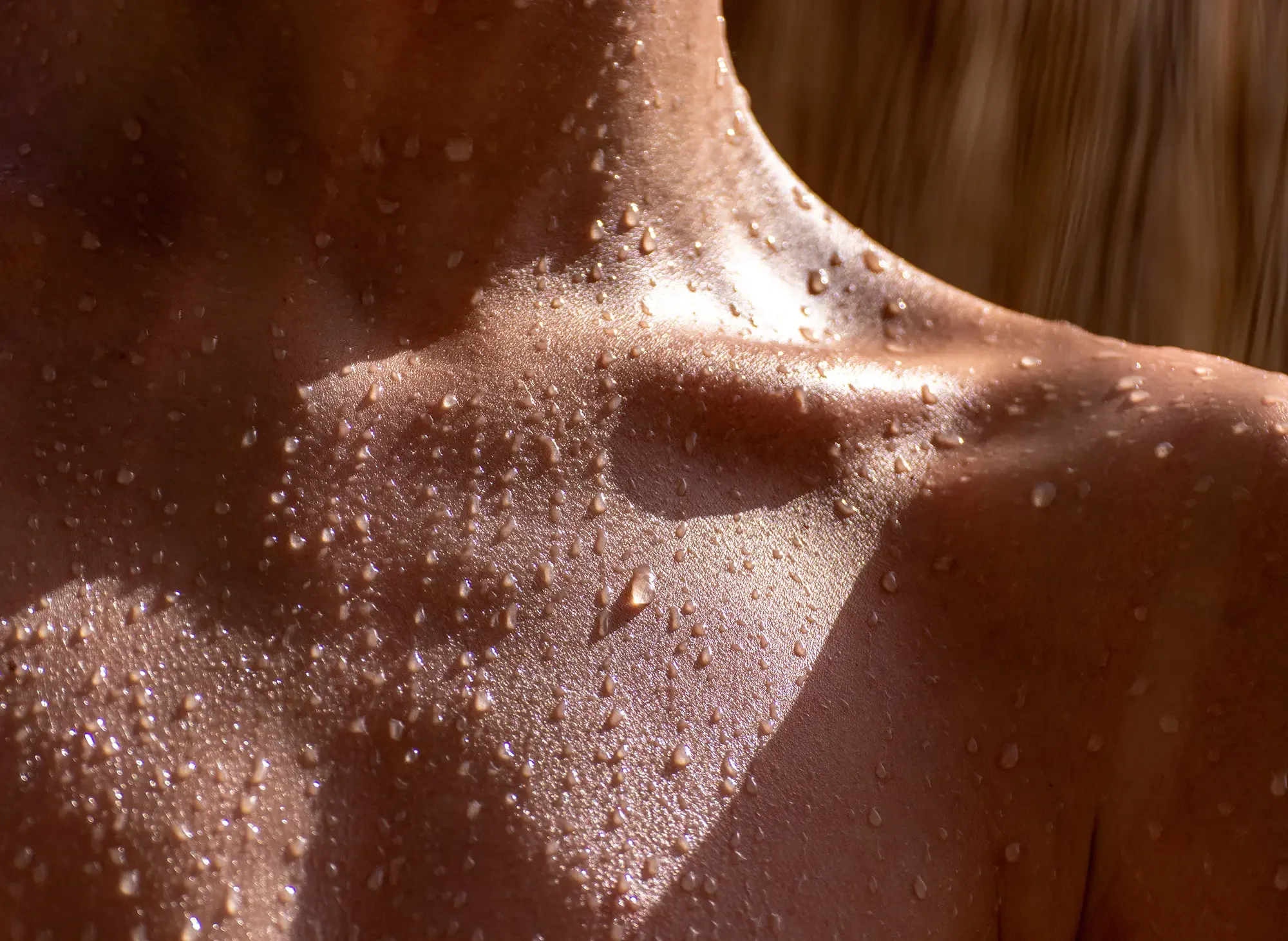 Close-up of a person's chest with water droplets on skin