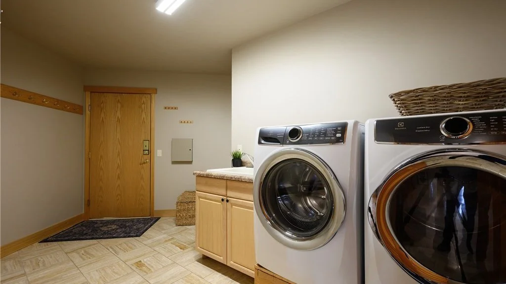 Utility room with front loading washer and dryer and sink with lower cupboard at 5067 E 26th Dr Bellingham WA 98226