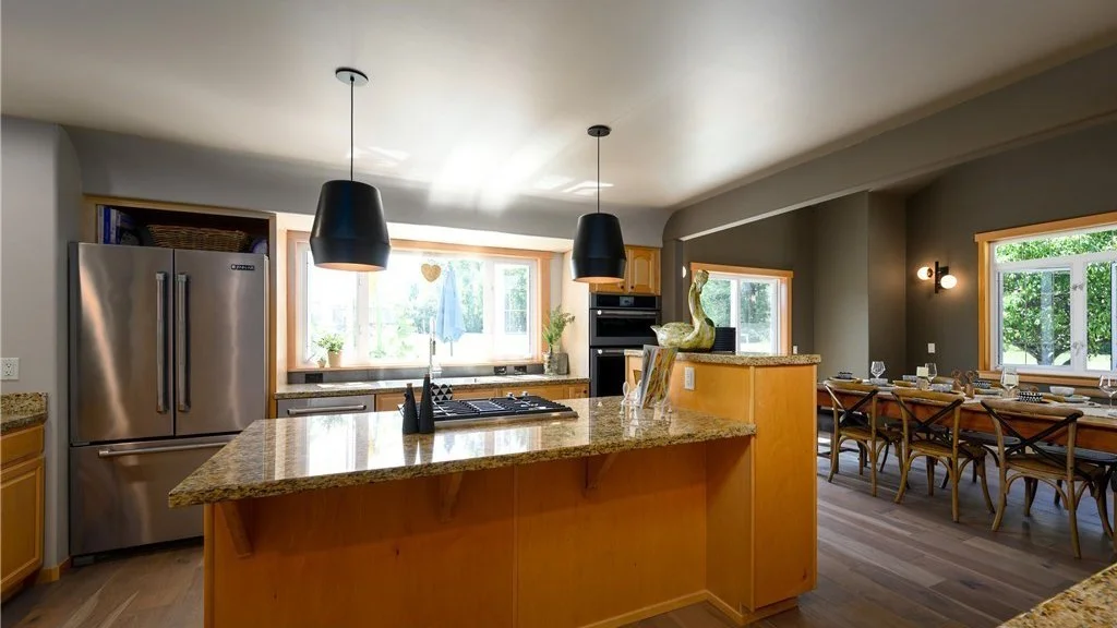 Kitchen with stainless steel fridge, island and partial dining room at 5067 E 26th Dr Bellingham WA 98226
