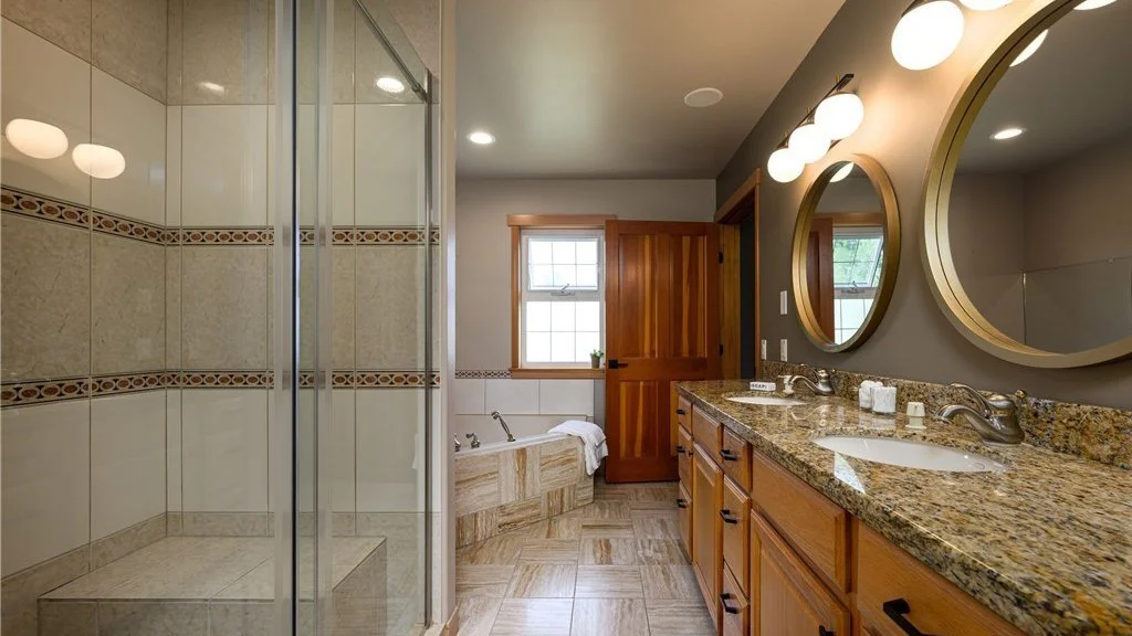 Bathroom with roll-in shower and double sinks with lower cupboards at 5067 E 26th Dr Bellingham WA 98226