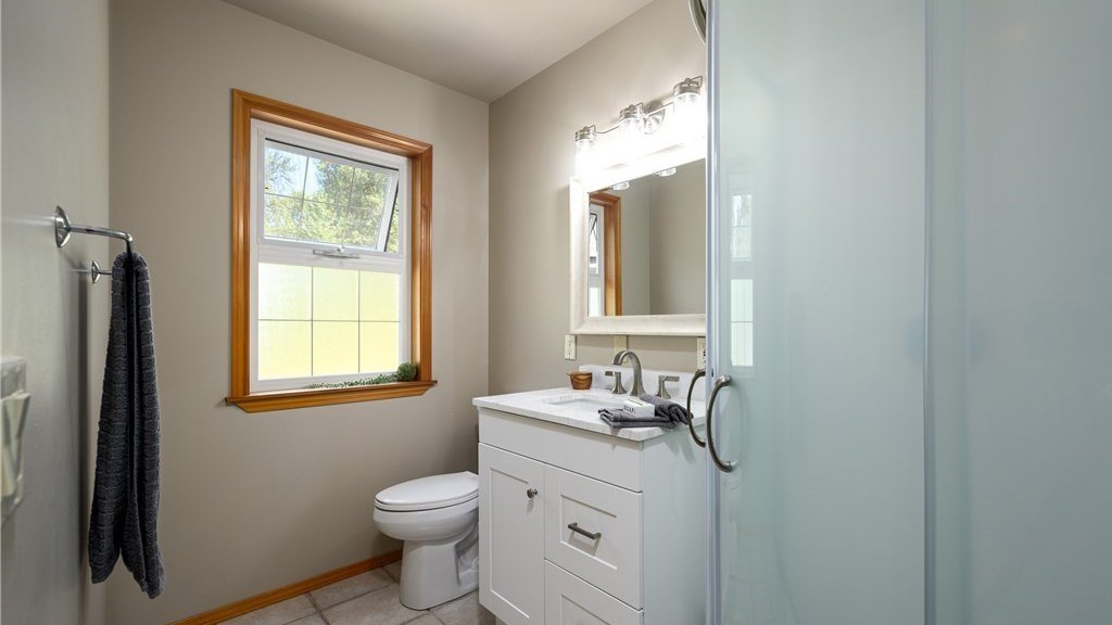 Bathroom with toilet, sink with vanity and lower cupboards and window at 5067 E 26th Dr Bellingham WA 98226