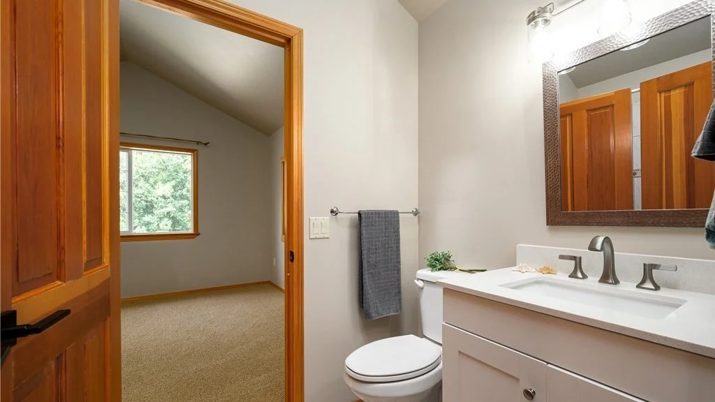 Bathroom with toilet and sink, mirror and lower cupboards at 5067 E 26th Dr Bellingham WA 98226