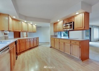 Kitchen with upper and lower cabinets, hardwood floors and recessed lighting at 1300 28th Avenue Court, Milton, WA 98354