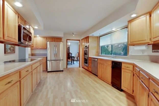 Kitchen with upper and lower cabinets, stainless steel appliances and well lit work surfaces at 1300 28th Avenue Court, Milton, WA 98354