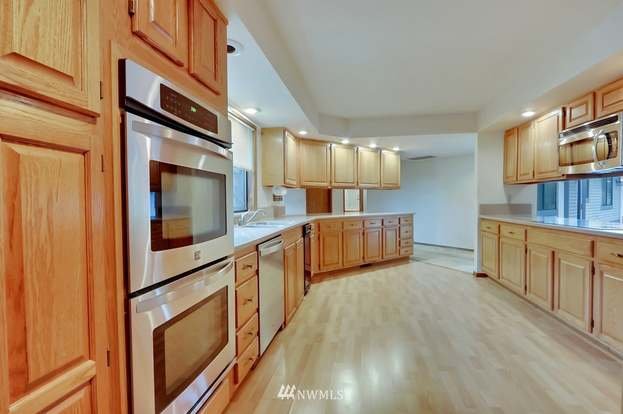 Kitchen with hardwood floors, upper and lower cabinets and double ovens at 1300 28th Avenue Court, Milton, WA 98354
