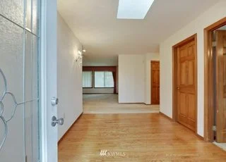 Front door entrance with hardwood floors and skylight leading into living room at 1300 28th Avenue Court, Milton, WA 98354