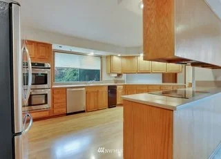 Kitchen with stainless steel appliances, hardwood floors and large windows above sink at 1300 28th Avenue Court, Milton, WA 98354