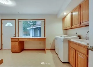 Utility room with roll under counter, upper and lower cabinet storage and tiled floors at 1300 28th Avenue Court, Milton, WA 98354