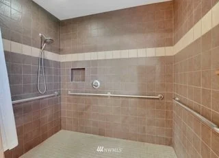 Spacious roll in shower with grab bars on all three walls at 1300 28th Avenue Court, Milton, WA 98354