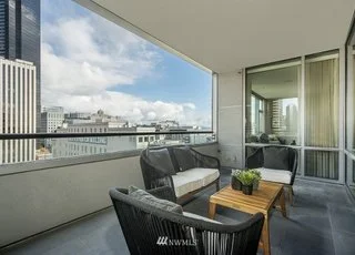 Balcony with lounging area and view of city at 715 2nd Ave #1703 Seattle WA 98104
