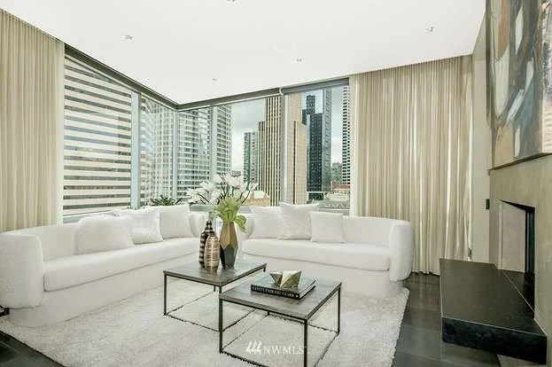 Living room with wrap around floor to ceiling windows and granite floors at 715 2nd Ave #1703 Seattle WA 98104