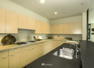 Kitchen with upper and lower cabinets on two walls with double stainless steel sink at 715 2nd Ave #1703 Seattle WA 98104