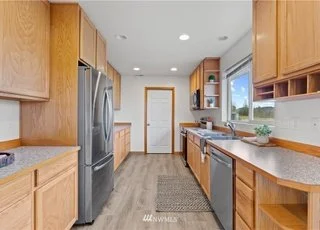 Kitchen with long counters, cupboards and stainless steel appliances at 12112 Roosevelt Rd, Snohomish, WA 98290