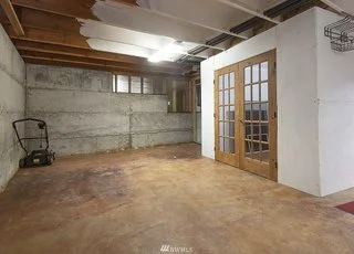 Garage with sealed concrete flooring and paned double doors into home at 19607 Heinz Pl, Lynnwood, WA 98036