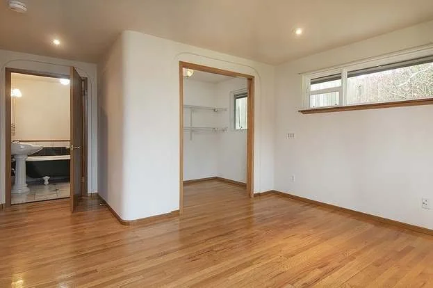 Bedroom with double wide roll in closet, hardwood flooring and entry into bathroom at 19607 Heinz Pl, Lynnwood, WA 98036