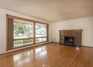 Living area with floor to ceiling windows, hardwood flooring and fireplace at 19607 Heinz Pl, Lynnwood, WA 98036