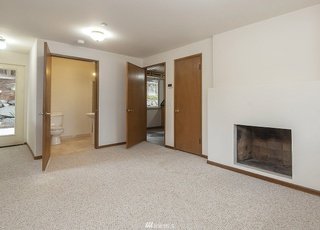 Bedroom with low pile carpeting, recessed fireplace and extra wide door into bathroom at 19607 Heinz Pl, Lynnwood, WA 98036