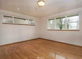 Bedroom with windows on two walls and hardwood flooring at 19607 Heinz Pl, Lynnwood, WA 98036