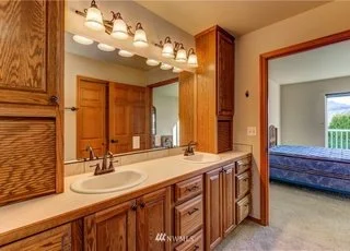 Bathroom with double sinks, vanity lighting and upper and lower cabinets at 104 Quail Lane Cashmere WA 98815