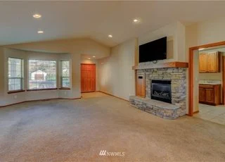 Living room with fireplace, bay windows and front door at 104 Quail Lane Cashmere WA 98815